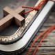 Closeup of simple wooden Christian cross necklace on holy Bible